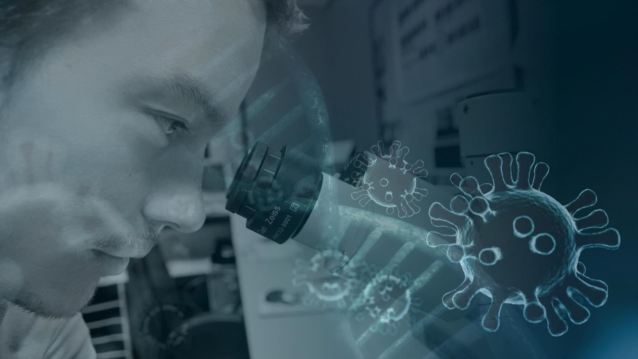 Image of man looking into a microscope.